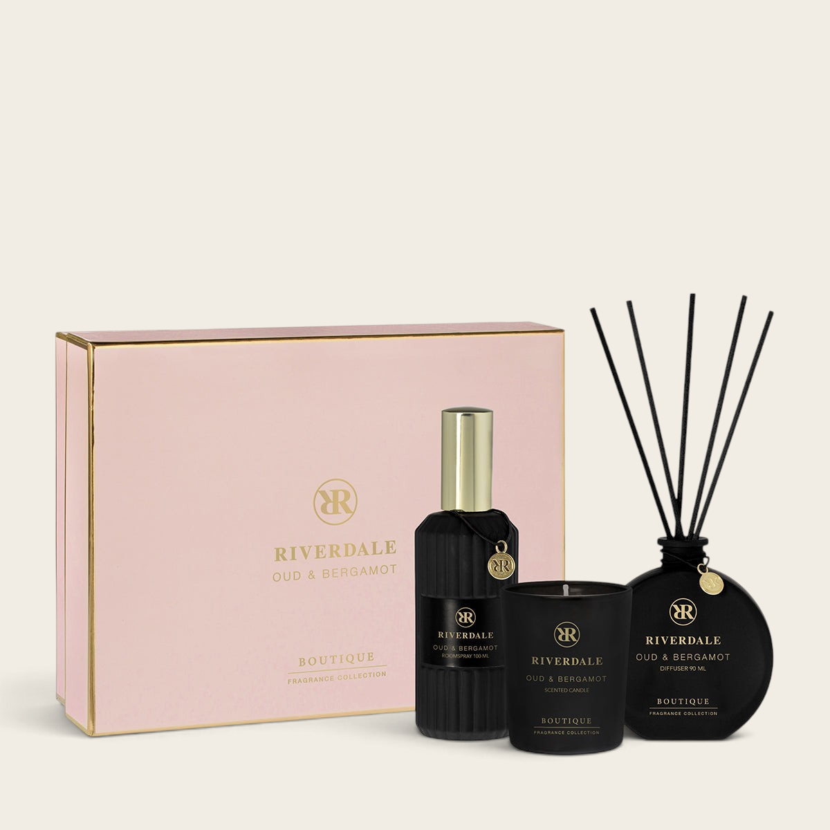 Riverdale Oud & Bergamot gift set featuring a room spray, scented candle, and reed diffuser in a pink presentation box.