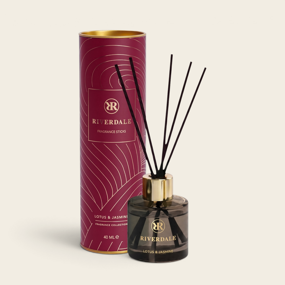 Riverdale Lotus & Jasmine fragrance sticks in a burgundy tube with gold accents and a glass diffuser bottle.