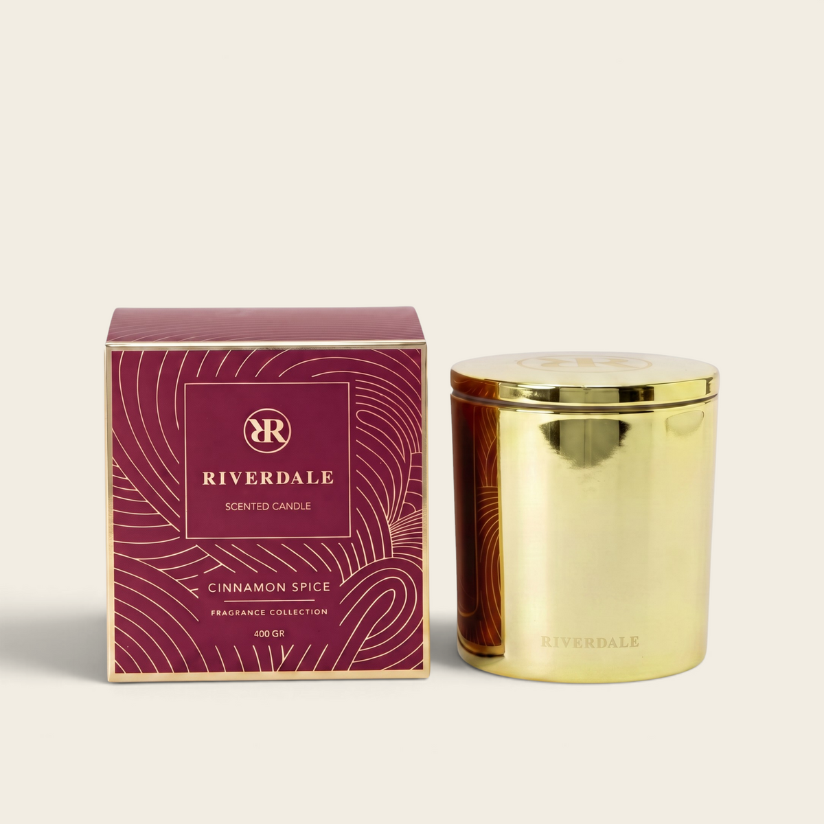 Riverdale Cinnamon Spice scented candle in a gold metallic jar with a matching burgundy patterned gift box