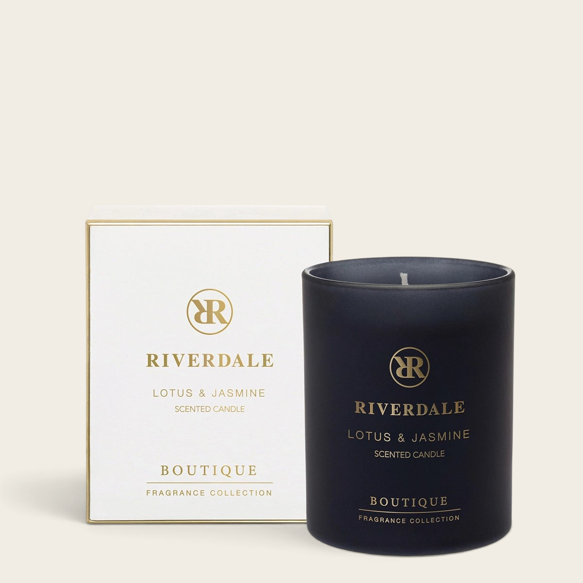 Riverdale Boutique scented candle in a matte black glass jar with gold branding and matching gift box.