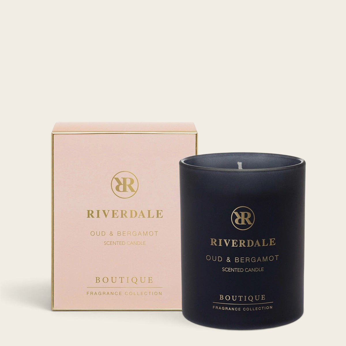 Riverdale Boutique Oud & Bergamot scented candle in a matte black glass jar with a matching pale pink gift box.