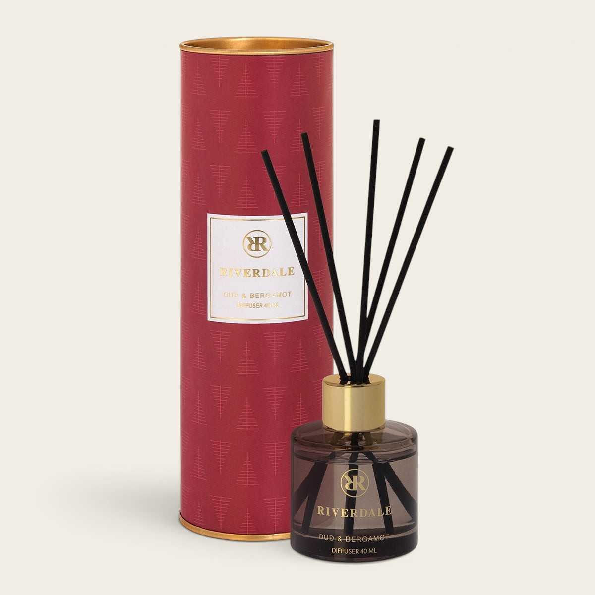 Riverdale Oud & Bergamot reed diffuser in a festive red gift tube with black reeds and a glass bottle.