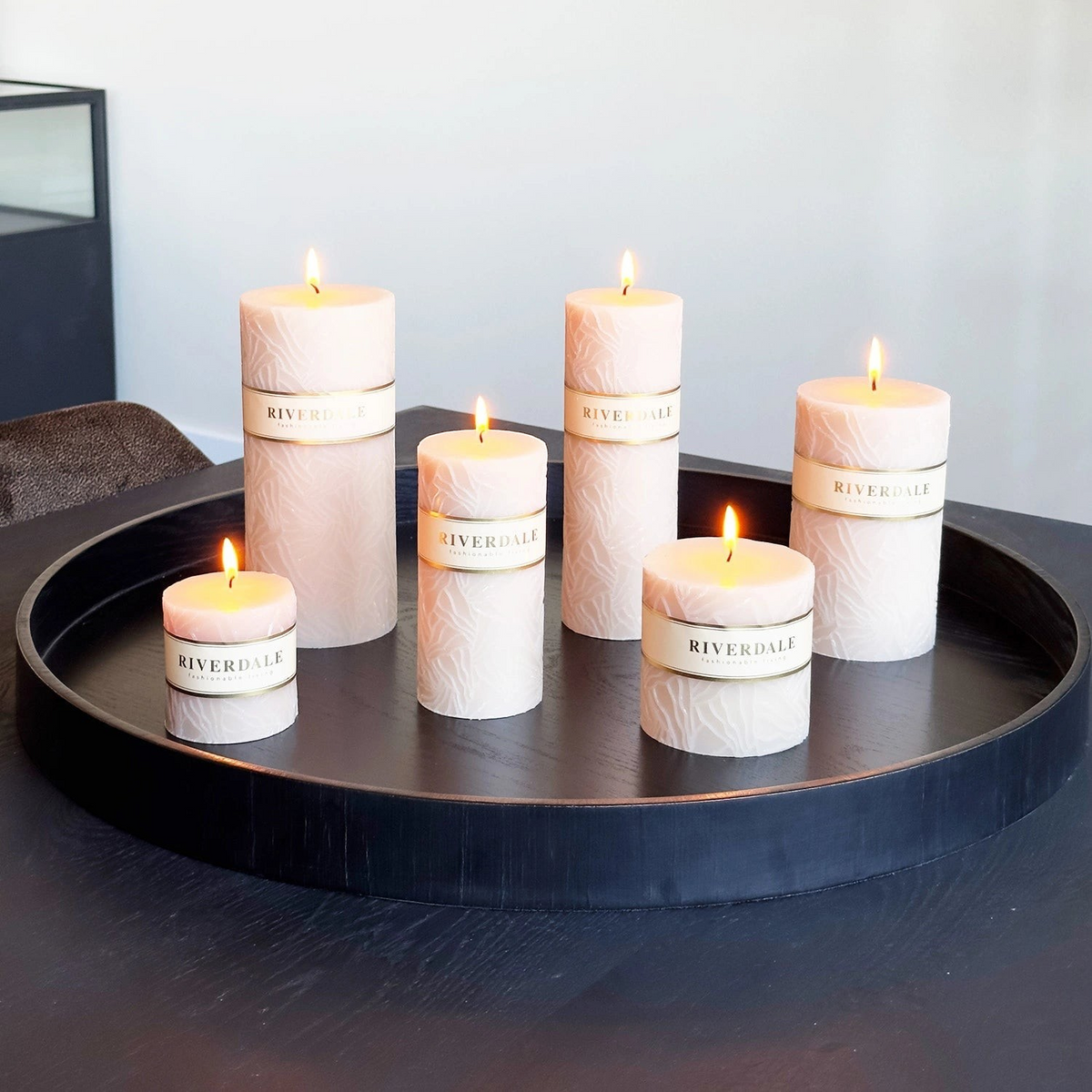 Riverdale Wave sand-colored pillar candles with textured oyster mushroom pattern on a black round decorative tray